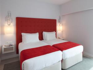 a hotel room with a bed and two lamps at Lutecia Smart Design Hotel in Lisbon
