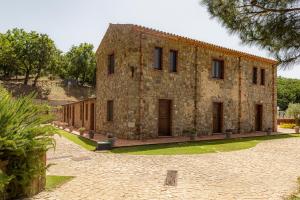 een groot stenen gebouw met een binnenplaats ervoor bij Casena Mongerrati in Collesano