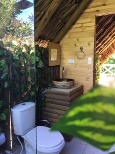 a bathroom with a toilet and a bath tub at Glamping Paihuen in Villavicencio