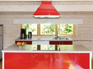 a kitchen with a red island with a sink at 4 person holiday home in TYRINGE in Tyringe