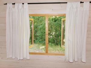 a window with white curtains in a room at 4 person holiday home in TYRINGE in Tyringe