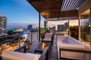 卡塔赫納的住宿－Oz Hotel Luxury，阳台配有白色家具,享有城市美景。
