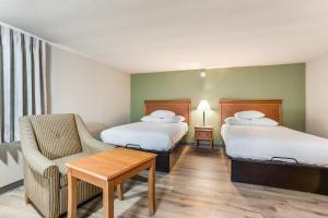 una habitación de hotel con 2 camas y una silla en Americas Best Value Inn - Lebanon, en Lebanon