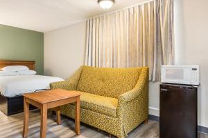 une chambre d'hôtel avec un lit, un canapé et une table dans l'établissement Americas Best Value Inn - Lebanon, à Lebanon