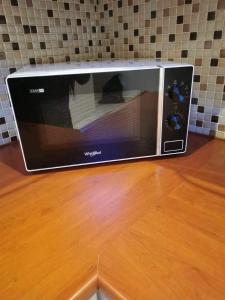 a microwave sitting on top of a wooden table at Grande Villa de Prestige près de Paris Réunions Familiales, Professionnelles et Événements in Gien