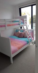 a bedroom with two bunk beds with pillows at Luxury Beach Front Appartment in Rosebud