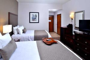 ein Hotelzimmer mit 2 Betten und einem Flachbild-TV in der Unterkunft Diamond Lodge in Karatschi
