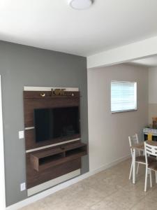 a living room with a flat screen tv on a wall at Apartamento Cantinho da Serra in Nova Friburgo
