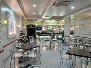 a restaurant with tables and chairs and a christmas tree at Hotel Mari Carmen in Guadix