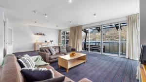a living room with a couch and a table at Marina Views - Apt 207 in Queenstown
