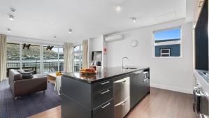 a kitchen with a counter and a living room at Marina Views - Apt 207 in Queenstown
