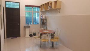 a kitchen with a table and chairs in a room at HOMESTAY EIJAZ KUALA ROMPIN in Kuala Rompin