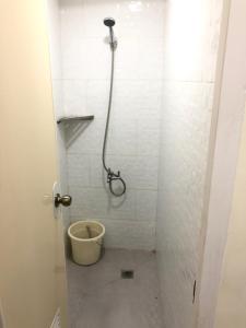 a bathroom with a shower with a bucket in it at Snoozeph in Manila