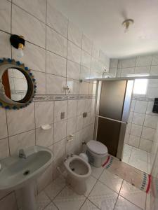 a bathroom with a toilet and a sink and a shower at Departamentos Vale Encantado in Bombinhas