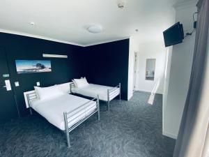 a bedroom with two beds and a blue wall at Based by the Lake in Taupo