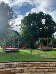 a park with two benches and a gazebo at Villas do Pratagy CocoBambu in Maceió