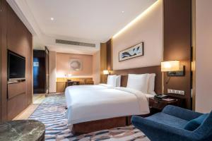 מיטה או מיטות בחדר ב-Crowne Plaza Dalian Sports Center, an IHG Hotel