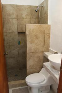 a bathroom with a shower with a toilet and a sink at Rooms in Cancun Airport in Cancún