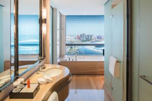 La salle de bains est pourvue d'un lavabo et d'une grande fenêtre. dans l'établissement Crowne Plaza Dalian Sports Center, an IHG Hotel, à Dalian