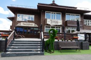a green statue sitting on a bench in front of a building at Gubernskaya Hotel in Sheregesh