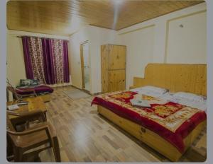 a bedroom with a bed and a table and a chair at The Paradise, Old Manali in Manāli