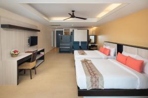 a hotel room with two beds and a desk at Anyavee Tubkaek Beach Resort- SHA Plus in Tab Kaek Beach