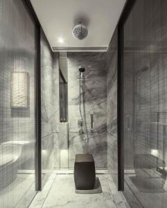 a bathroom with a shower and a chair at InterContinental Zhuhai, an IHG Hotel in Zhuhai