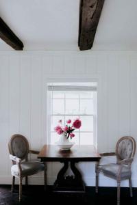 a vase of flowers on a table with two chairs at Mayhurst Estate in Orange