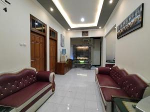 a lobby with two couches and a television in a building at Abadi Homestay in Yogyakarta