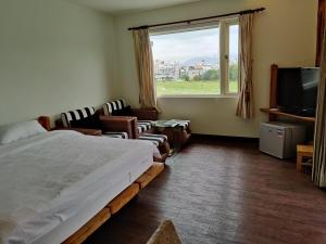 a bedroom with a bed and a large window at Two Dots On Line Homestay in Hualien City
