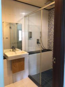y baño con lavabo y ducha acristalada. en Two Dots On Line Homestay, en Hualien City