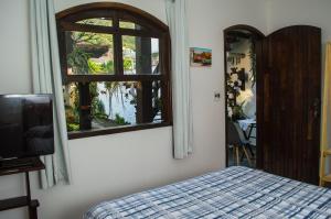 Schlafzimmer mit einem Bett und einem Fenster in der Unterkunft Noemia Brazil Cama e Café in Arraial do Cabo