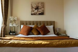 a bed with orange and white pillows in a bedroom at Brogans Bar & Hotel in Trim