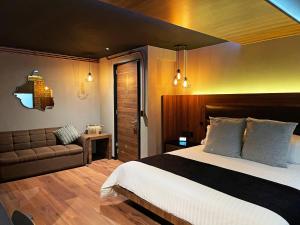 1 dormitorio con 1 cama grande y 1 sofá en Cadillac Hotel Boutique en Ciudad de México