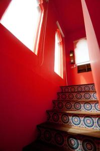 a stairway with a red wall and a stair case at Raid Garden Boutique Hotel in Magong