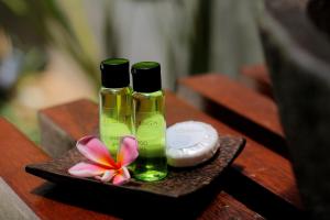 two bottles of soap and a flower on a plate at Bingin Lodge Uluwatu in Uluwatu