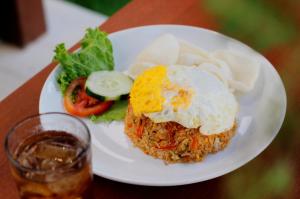 a plate of food with a fried egg and a salad at Bingin Lodge Uluwatu in Uluwatu