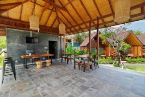 an outdoor patio with a table and chairs at Bingin Lodge Uluwatu in Uluwatu