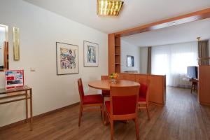 a room with a table and chairs and a kitchen at Sunday Hotel Wiesbaden Niedernhausen Apartments in Niedernhausen