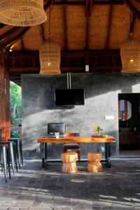 a dining room with a wooden table and chairs at Bingin Lodge Uluwatu in Uluwatu
