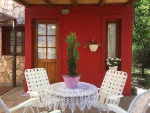 una mesa con una maceta en una casa roja en Raco De La Calma en Nono