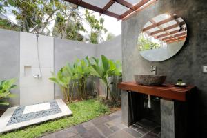a bathroom with a sink and a mirror at Bingin Lodge Uluwatu in Uluwatu