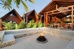 an outdoor patio with a fire pit in front of a house at Bingin Lodge Uluwatu in Uluwatu