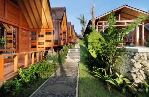 a row of wooden houses with a path between them at Bingin Lodge Uluwatu in Uluwatu