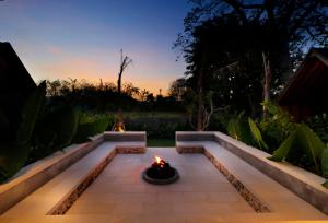a fire pit in a garden at dusk at Bingin Lodge Uluwatu in Uluwatu