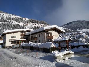 un edificio cubierto de nieve en el lateral de una montaña en Hotel Gesser, en Sillian