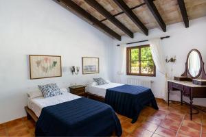 a bedroom with two beds and a sink and a mirror at Agroturismo SAIGO in Portocolom