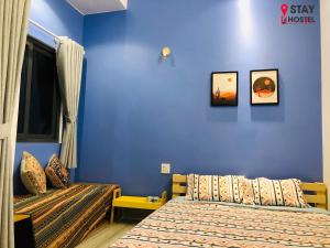 1 dormitorio con 2 camas y pared azul en STAY hostel 2 - 350m from the ferry en Rạch Giá