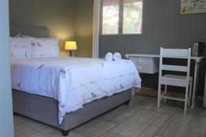 1 dormitorio con 1 cama con escritorio y silla en Hope's Rest 1 en Richards Bay