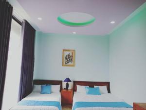 a bedroom with two beds and a green ceiling at Khách sạn Nghinh Phong Beach Tuy Hòa in Tuy Hoa